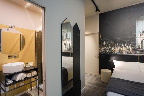 Habitación de hotel con baño con cama y espejo. en Theatrum Rooms and Suite, en Verona