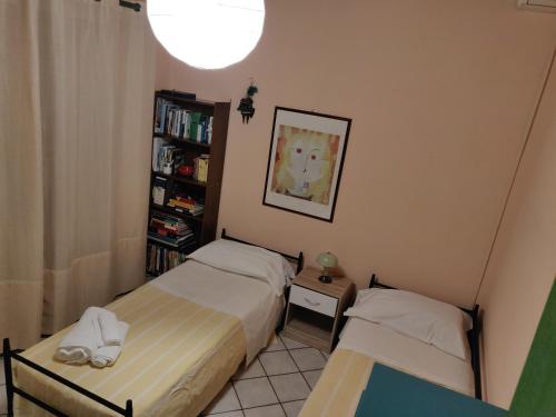 a bedroom with two beds and a book shelf at Villa con piscina in Vittoria