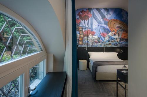 a room with a bed and a window with a mural at Theatrum Rooms and Suite in Verona