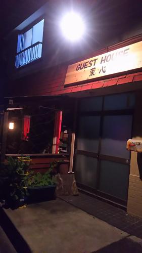 a guest house with a sign on the front of it at 伊豆 白浜 ゲストハウス茉心 in Shimoda