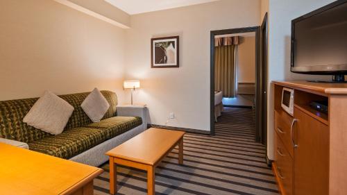 a living room with a couch and a flat screen tv at Best Western King George Inn & Suites in Surrey
