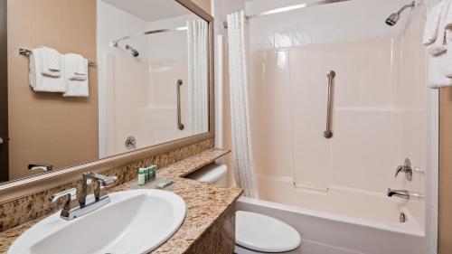 a bathroom with a sink and a toilet and a shower at Best Western King George Inn & Suites in Surrey