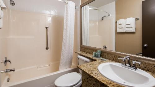 a bathroom with a sink and a toilet and a tub at Best Western King George Inn & Suites in Surrey