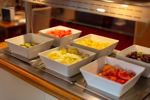 a tray filled with bowls of different types of fruit at Gran Hotel Soller in Sóller
