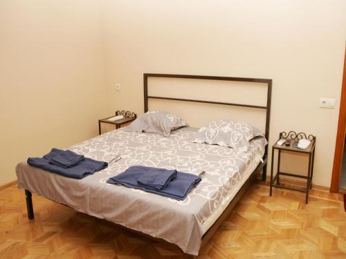 1 dormitorio con 1 cama con 2 toallas en Two Towers Guest House, en Kutaisi