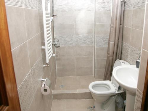 a bathroom with a shower and a toilet and a sink at Two Towers Guest House in Kutaisi