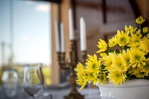 a white vase filled with yellow flowers on a table at Agriturismo Casale Ugolini in Montespertoli