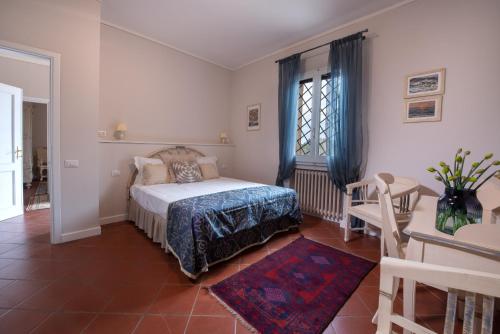 a bedroom with a bed and a table and a window at Agriturismo Casale Ugolini in Montespertoli