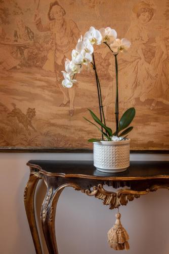 a vase of flowers on a table with a painting at Agriturismo Casale Ugolini in Montespertoli