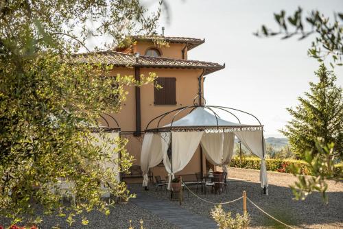 a building with a gazebo in front of it at Agriturismo Casale Ugolini in Montespertoli