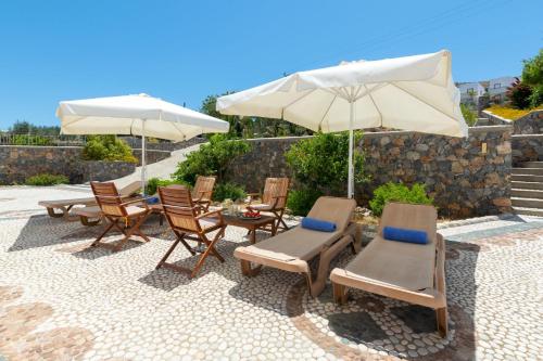 a group of chairs and umbrellas on a patio at George's Villas in Líndos