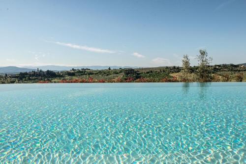 a large body of blue water with trees in the background at Agriturismo Casale Ugolini in Montespertoli