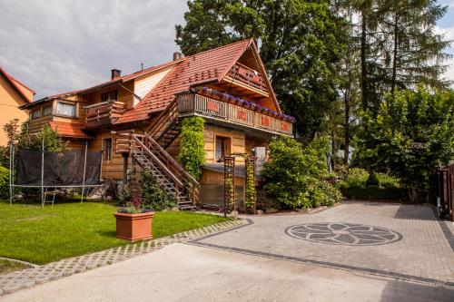 a wooden house with a staircase leading up to it at Willa Szarotka in Rabka-Zdrój