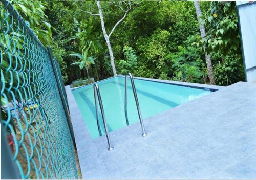 una piscina con una valla alrededor en Alfred Colonial Bungalow & Spice Garden en Kobbekaduwa