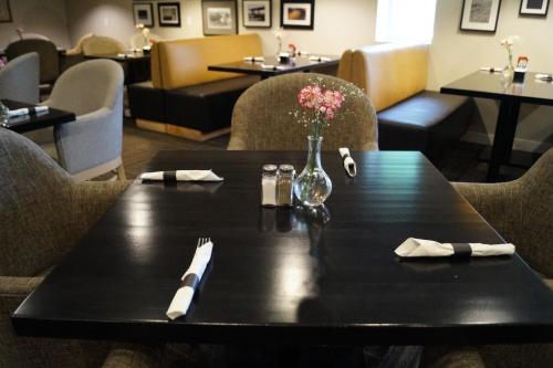 a black table with a vase of flowers on it at Radisson Hotel & Conference Centre Edmonton in Edmonton