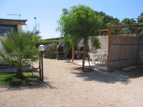 a garden with a bench and a fence and a tree at L'Araucaria turismo rurale in Santa Croce Camerina