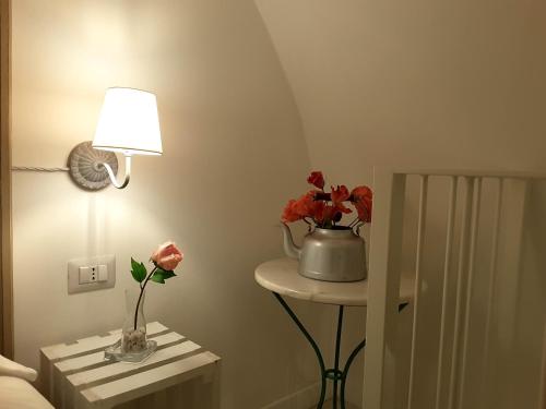 a room with a lamp and a table with flowers on it at SASSO BIANCO in Matera