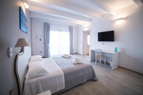 a white bedroom with a bed and a desk at La seconda Luna in Pollutri