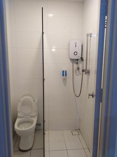 a bathroom with a toilet and a shower stall at The Wave Residence in Malacca