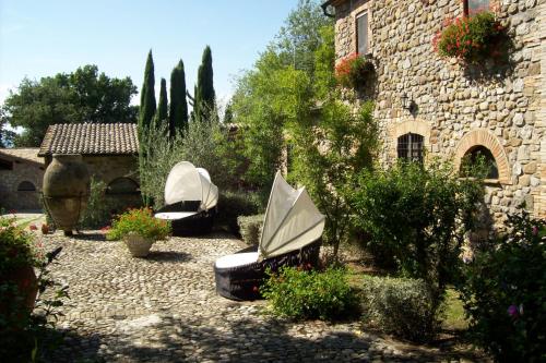 a garden with two chairs and an umbrella at Antico Podere Vitiano - Luxury country house in Castel Viscardo