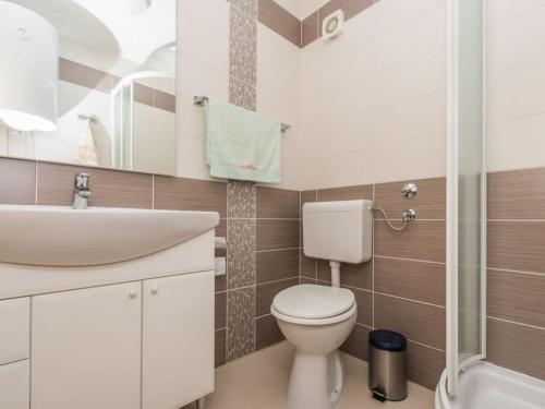 łazienka z białą toaletą i umywalką w obiekcie Apartment F-3 Klimno w mieście Klimno