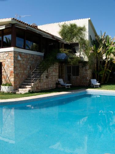 a large blue swimming pool in front of a house at Villa Relax en Benidorm in Benidorm