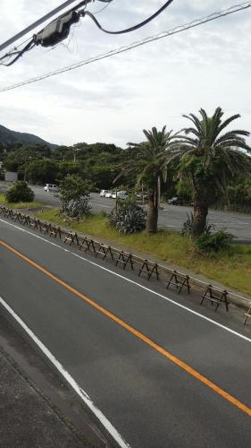 a street with a row of benches on the side of a road at 伊豆 白浜 ゲストハウス茉心 in Shimoda