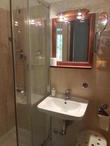 a bathroom with a sink and a shower with a mirror at B&B Le Stagioni in Potenza