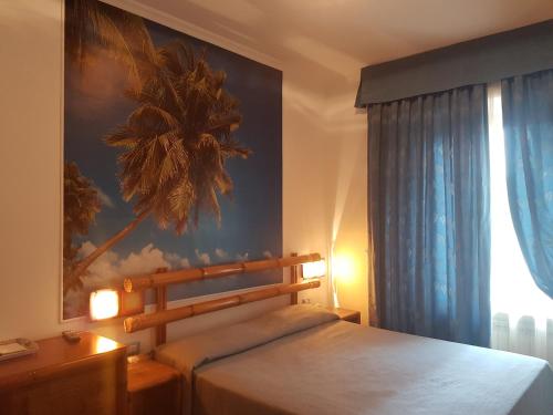 a bedroom with a bed and a palm tree painting on the wall at B&B Le Stagioni in Potenza