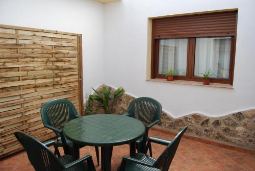 uma mesa verde e cadeiras num quarto com uma janela em Casas Rurales Mirador Al Castillo em Paracuellos
