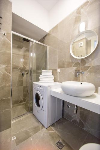a bathroom with a washing machine and a sink at Apart SKY Residence with sea view in DELMAR in Budva