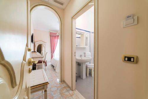 a bathroom with a tub and a sink and a mirror at Hotel Il Nido in Amalfi