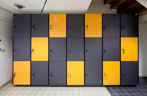 a locker room with yellow and black lockers at easyHotel Rotterdam City Centre in Rotterdam