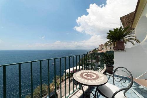 a balcony with a table and a view of the ocean at Hotel Il Nido in Amalfi