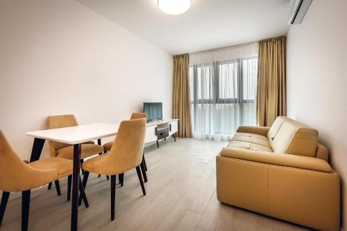 a living room with a couch and a table and chairs at Adria lux apartmens 2 in Sveti Stefan