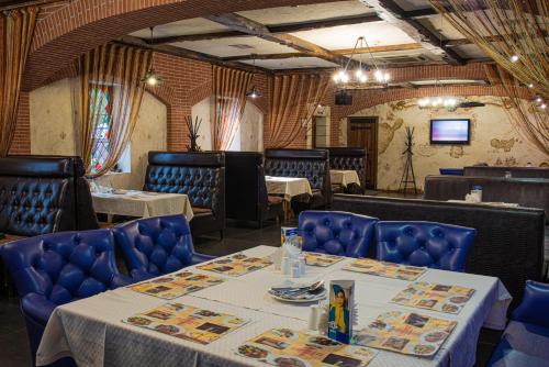 a dining room with tables and chairs and a television at JEPPESEN RESIDENCE in Almaty