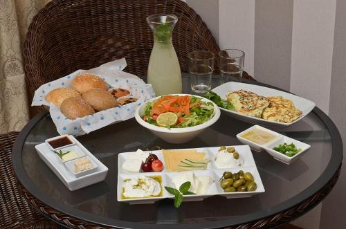 una mesa de cristal con platos de comida. en Hufsha Berama, en Had Nes