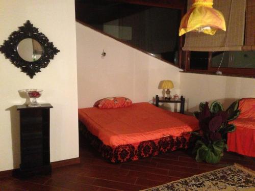 a bedroom with a red bed and a mirror at Magnolia House in Taurianova