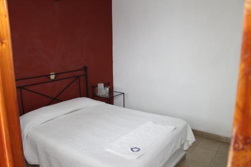 a small bedroom with a bed with a white blanket at Hotel Casablanca Tuxtla in Tuxtla Gutiérrez