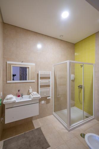 a bathroom with a glass shower and a sink at Rua de São Bento n.123 in Vila do Conde