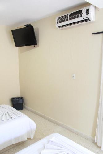 a room with two beds and a air conditioner on the wall at Hotel Casablanca Tuxtla in Tuxtla Gutiérrez