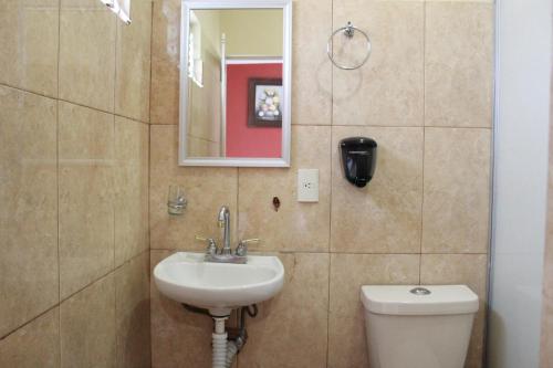 a bathroom with a sink and a toilet and a mirror at Hotel Casablanca Tuxtla in Tuxtla Gutiérrez