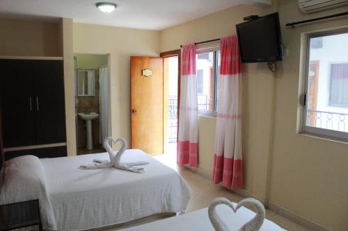 a hotel room with two beds with hearts on them at Hotel Casablanca Tuxtla in Tuxtla Gutiérrez