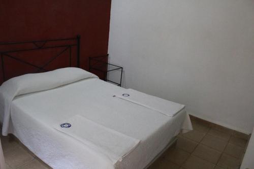a bed in a room with a white bedsheet at Hotel Casablanca Tuxtla in Tuxtla Gutiérrez