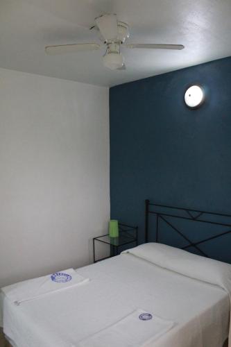 a bedroom with a white bed and a blue wall at Hotel Casablanca Tuxtla in Tuxtla Gutiérrez