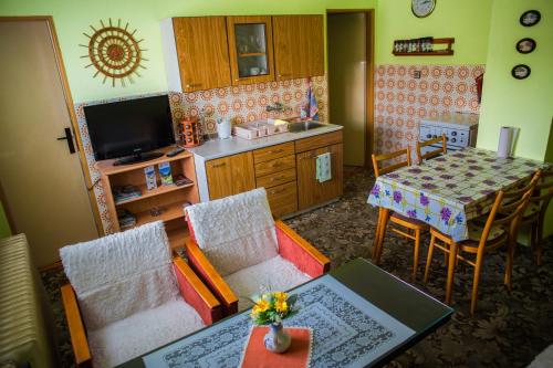 a living room with a table and a kitchen at Apartmán Štrba in Štrba