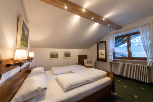 ein Schlafzimmer mit einem großen Bett und einem Fenster in der Unterkunft Gästehaus Alpenflora in Fischen im Allgäu