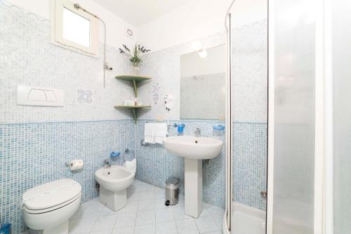 a blue tiled bathroom with a toilet and a sink at Hotel Il Nido in Amalfi