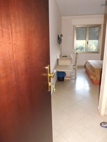 a door to a room with a bed and a desk at Hotel Sagittario in San Sperate