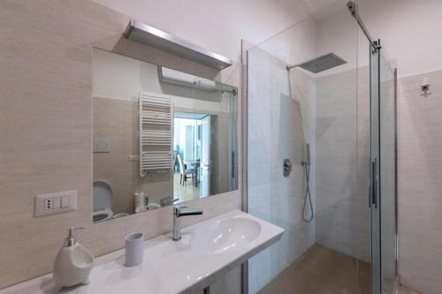 une salle de bain avec un lavabo et une douche avec un miroir dans l'établissement Aragonese Luxury Rooms, à Naples